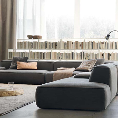 a bookshelf behind a sofa set