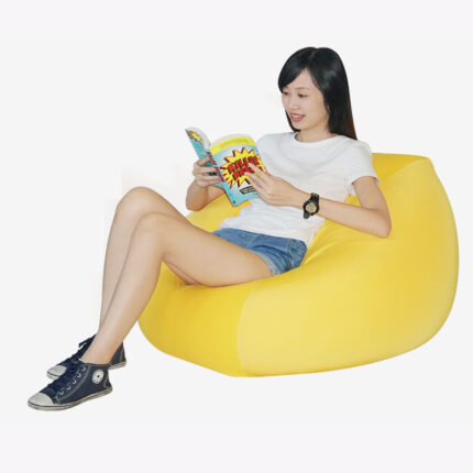 a woman sitting on yellow fabric bean bag